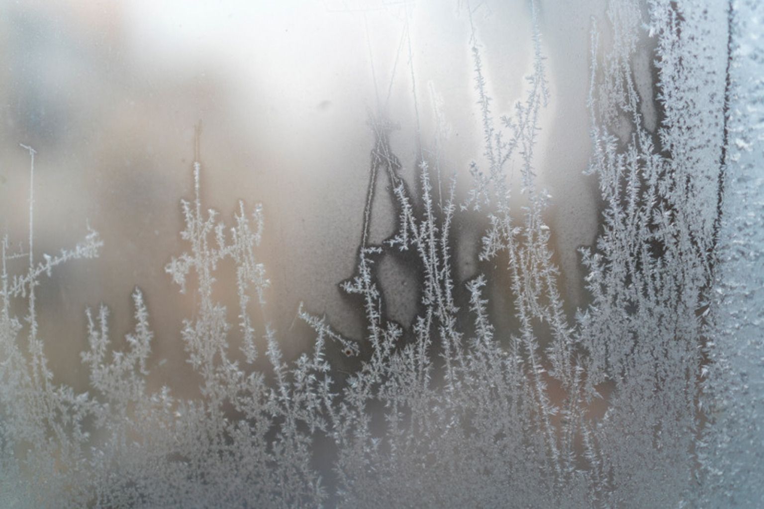 Iskrystaller og frost på en vinduesrude om vinteren